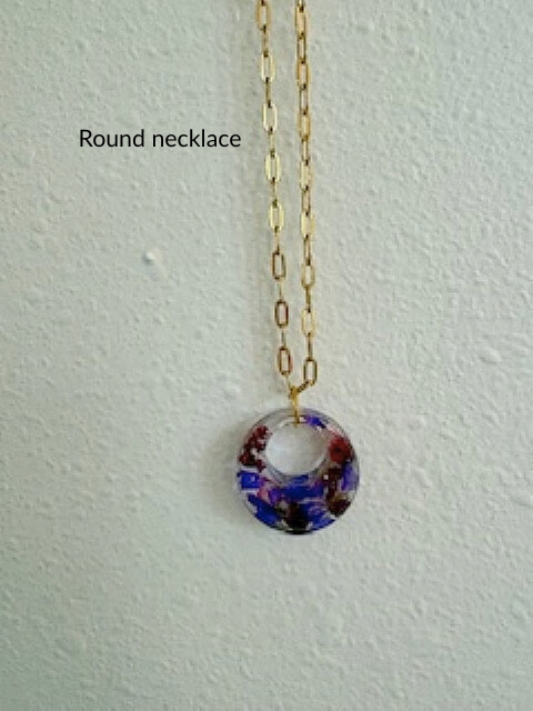 Handmade round resin necklace with purple flowers